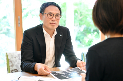 スタッフがお客さまに資料を示しながら資金計画を説明している様子