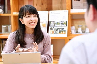 打ち合わせで笑顔で提案するスタッフ