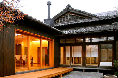 夕暮れに灯りがともる再生された日本家屋の外観