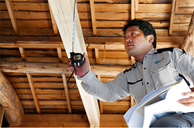 小屋裏で施工状況を確認する職人